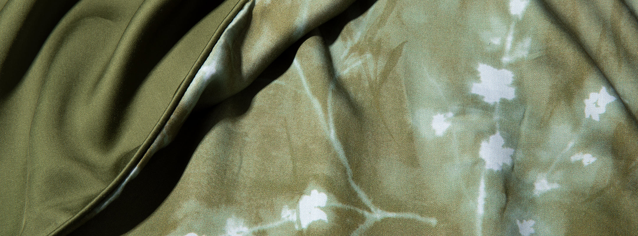 Close-up image of the Floral Evergreen pattern with a small section of the plain Evergreen color in the bottom left corner
