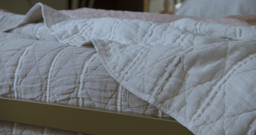 Video panning around a close-up view of the reversible Heritage Quilt on a dressed bed