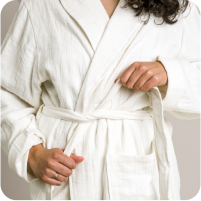 Image of a woman wearing the white Dr. Weil Featherweight Robe and tying the belt
