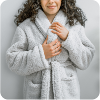 Image of a woman smiling and wearing the gray Sunday Morning Robe