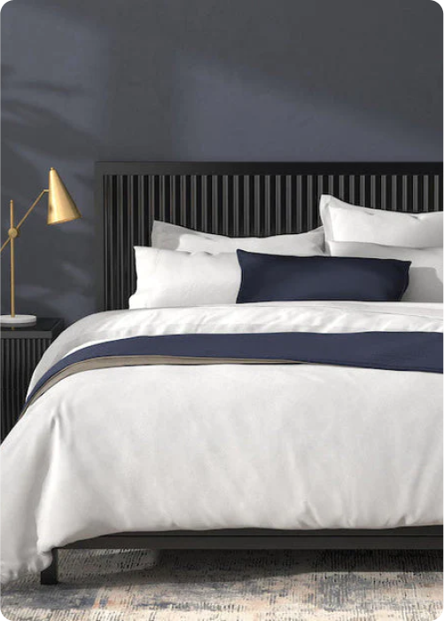 Image of a navy-colored room with all-white bedding and various Midnight accents