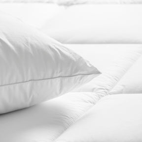Image of a pillow on a tufted mattress pad
