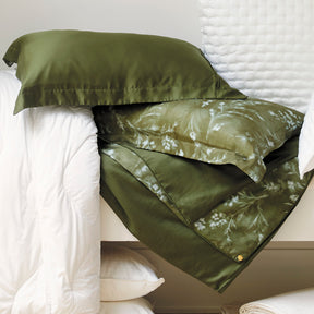 Image of various white bedding surrounding the reversible Floral Evergreen Duvet Cover + Cooling and Pillow Shams