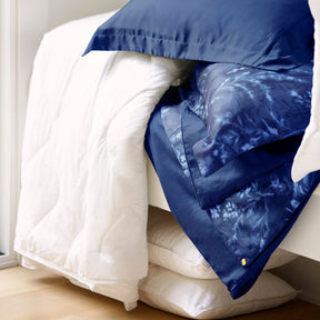 Image of various white bedding surrounding the reversible Floral Midnight Duvet Cover + Cooling and Pillow Shams