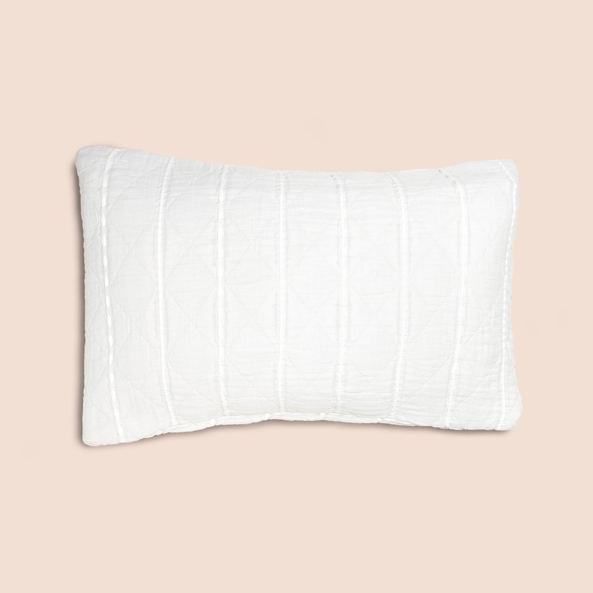 Image of the all-white side of the Heritage Pillow Sham on a pillow with a light pink background