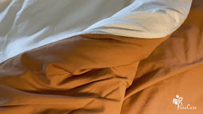 Video of the Ivory/Clay Duvet Cover + Cooling. The video pans over the cover, then shows a person tying the cover to an insert, zipping the cover up, and showing the neatly-made bed
